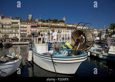 Frankreich, Alpes Maritimes, Cannes, Fischer in seiner traditionellen fishboat im Alten Hafen, mit dem Stadtteil Suquet im Hintergrund Stockfoto