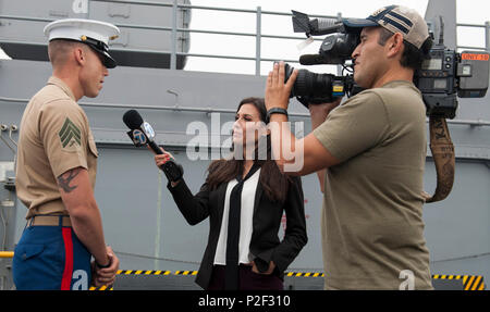 160901-N-MZ 309-027 SAN PEDRO, Kalifornien (Sept. 1, 2016) - US Marine Corps Sgt. Tyler Dutton, 3 Bataillon zugeordnet, 5. Marine Regiment, antwortet auf die Fragen in einem Interview mit ABC TV-Persönlichkeit Leslie Lopez auf Amphibisches Schiff USS America (LHA 6) Flight Deck während der Eröffnungs-Los Angeles Flotte Woche. Flotte Woche bietet der Öffentlichkeit die Möglichkeit, Schiffe zu Tour, treffen Segler, Marines, und die Mitglieder der Küstenwache und ein besseres Verständnis dafür, wie das Meer Service der nationalen Verteidigung der Vereinigten Staaten und die Freiheit der Meere Unterstützung gewinnen. (U.S. Marine Foto von Masse Communi Stockfoto