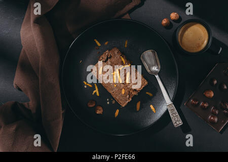 Blick von oben auf die Schokolade Kuchen mit Orangenschale auf schwarze Platte Stockfoto