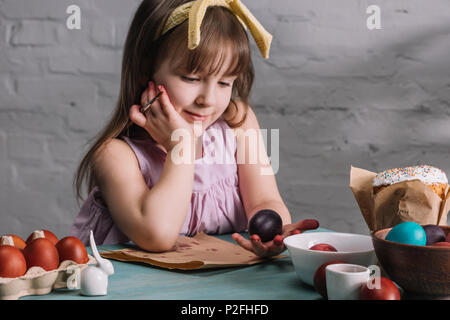 Adorable Zicklein an bemalte Ei in der Hand suchen, Ostern Konzept Stockfoto