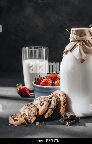 Nahaufnahme der Chocolate Chip Cookies mit Milch und Erdbeeren Stockfoto