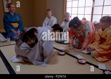 Während einer japanischen Teezeremonie im Yayoi Kimono Shop and Cultural School in Naha, Okinawa, servieren die Lehrer Mochi, während sie die richtige Etikette und Verbeugung demonstrieren. Das in traditionellen Kimonos gekleidete SOFAPERSONAL erlernt kulturelle Praktiken, höfliche Sätze und Bräuche für den Besuch japanischer Häuser. Der Kurs, der von Marine Corps Installations Pacific und Marine Corps Base Camp Butler veranstaltet wird, bietet III MEF Service-Mitgliedern praktische Erfahrung in japanischen Traditionen, Zeremonien und Gastfreundschaft, einschließlich der Zubereitung und dem Servieren von Matcha-Tee und Erfrischungen. Stockfoto