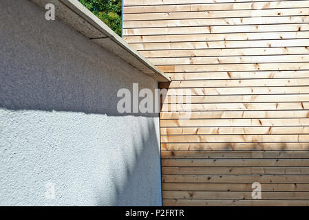 Renovierte weiß ciment Wand- und isolierende Holzverkleidung im Innenhof im Freien Stockfoto