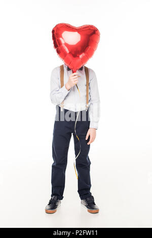 Stilvolle kleine Junge versteckt sich hinter rote herzförmige Ballons isoliert auf weißem Stockfoto