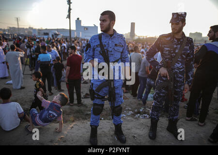 Gaza, Gazastreifen. 15 Juni, 2018. Bewaffnete Polizisten bewachen Palästinenser, wie Sie das Gebet des Eid al-Fitr, ein dreitägiges Fest, dass das Ende des muslimischen Fastenmonats Ramadan fasten Marken durchführen, an der Israel-Gaza Grenze im Osten von Gaza, Gazastreifen, 15. Juni 2018. Credit: Wissam Nassar/dpa/Alamy leben Nachrichten Stockfoto