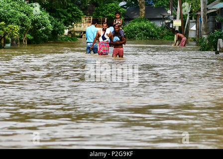 Agartala, Andhra Pradesh, Indien. 15 Juni, 2018. Männer sind zu Fuß durch die überschwemmten Wasser. Indische Dorfbewohner verlassen ihre Häuser mit ihren Kindern als das Hochwasser hat ihre Häuser nach einem heftigen Regenguss in Baldakhal Dorf ein, am Stadtrand von agartala die Hauptstadt des nordöstlichen Bundesstaates Andhra Pradesh, Indien. National Disaster Response Force (NDRF) Personal sind die Rettung von Menschen, Kinder von unterschiedlichen Orten aus und an sicheren Orten. Credit: Abhisek Saha/SOPA Images/ZUMA Draht/Alamy leben Nachrichten Stockfoto