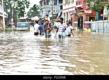 Agartala, Andhra Pradesh, Indien. 15 Juni, 2018. Männer sind zu Fuß durch die überschwemmten Wasser. Indische Dorfbewohner verlassen ihre Häuser mit ihren Kindern als das Hochwasser hat ihre Häuser nach einem heftigen Regenguss in Baldakhal Dorf ein, am Stadtrand von agartala die Hauptstadt des nordöstlichen Bundesstaates Andhra Pradesh, Indien. National Disaster Response Force (NDRF) Personal sind die Rettung von Menschen, Kinder von unterschiedlichen Orten aus und an sicheren Orten. Credit: Abhisek Saha/SOPA Images/ZUMA Draht/Alamy leben Nachrichten Stockfoto