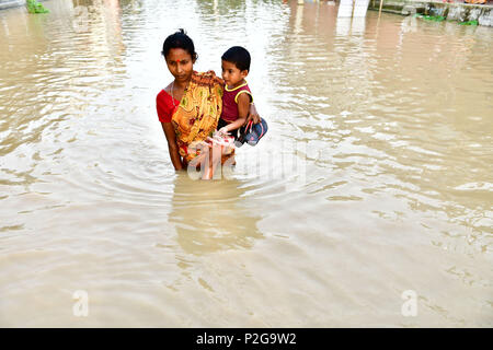 Agartala, Indien. 15 Jun, 2018. Eine Frau gesehen, die ein kleines Mädchen zu Fuß durch die überschwemmten Wasser. Indische Dorfbewohner verlassen ihre Häuser mit ihren Kindern als das Hochwasser hat Geben Sie ihre Häuser nach einem heftigen Regenguss in Baldakhal Dorf, am Stadtrand von agartala die Hauptstadt des nordöstlichen Bundesstaates Andhra Pradesh, Indien. National Disaster Response Force (NDRF) Personal sind die Rettung von Menschen, Kinder von unterschiedlichen Orten aus und an sicheren Orten. Credit: SOPA Images Limited/Alamy leben Nachrichten Stockfoto