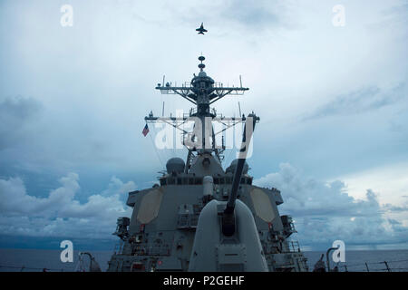 160918-N-PD 309-057 philippinischen Meer (bis 30. 18, 2016) Eine F/A-18E Super Hornet fliegt über der Arleigh-Burke-Klasse geführte Anti-raketen-Zerstörer USS Benfold (DDG65) als Teil des Flugbetriebs während der Valiant Shield 2016. Valiant Shield ist eine Biennale, nur in den USA, Feld - Training mit Fokus auf die Integration der gemeinsamen Ausbildung der US-Streitkräfte. Dies ist die sechste Übung in der Valiant Shield-Serie, die 2006 begann. Benfold ist auf Patrouille mit Carrier Strike Group fünf im philippinischen Meer Unterstützung der Sicherheit und Stabilität in der Indo-Asia-Pazifik-Region. (U.S. Marine Foto durch Massenmedien. Stockfoto