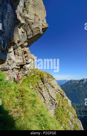 Frau Wandern auf Klettersteig unter überhängenden Felsen, Trans-Lagorai, Lagorai, Dolomiten, UNESCO Weltnaturerbe D Stockfoto