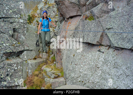 Frau Wandern auf Klettersteig zwischen Felsblöcken, Trans-Lagorai, Lagorai, Dolomiten, UNESCO Weltnaturerbe Dolomiten Stockfoto