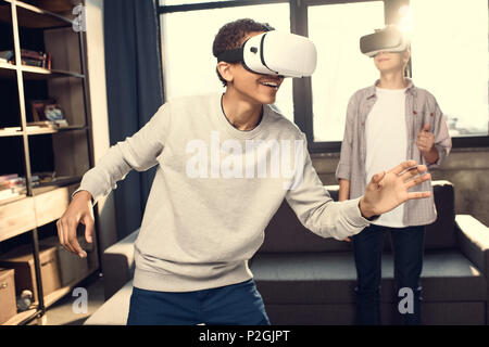 Teenager tragen Virtuelle Realität Headsets zu Hause, Teenager spielen Videospiele Konzept Stockfoto