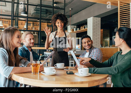 Junge afrikanische amerikanische Frau Kellnerin, die Aufträge von Kunden in Cafe Stockfoto