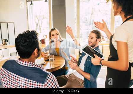 Junge afrikanische amerikanische Frau Kellnerin, die Aufträge von Kunden in Cafe Stockfoto