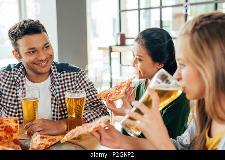 Gruppe von jungen multiethnischen Freunde in Pizza im Cafe Stockfoto