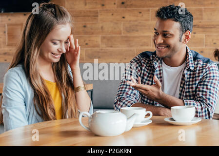 Lächelnden jungen Mann zu schüchtern Frau im Cafe sitzen Stockfoto