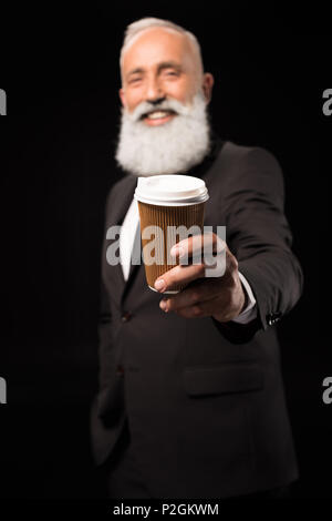 Halbe Länge geschossen von lächelnden Geschäftsmann im Anzug, der eine verfügbare Kaffeetasse Stockfoto
