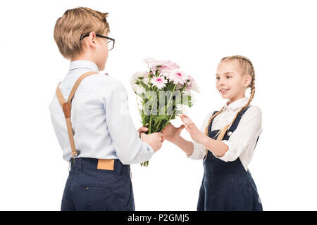 Vorpubertären jungen präsentieren Blumen lächeln kleines Mädchen isoliert auf weiss Stockfoto