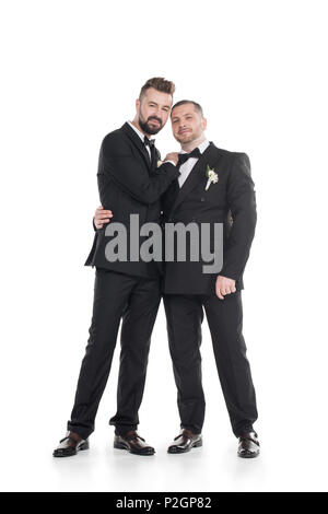 Homosexuelle Paare der Bräutigam in Smokings umarmen beim zusammen stehen auf weißen isoliert Stockfoto