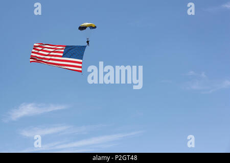 Ein Mitglied der US-Navy Leap Frogs Fallschirm Team steigt, während eine amerikanische Flagge hinter ihm Trails bei der Eröffnung der 2016 MCAS Miramar Air Show an Bord der Marine Corps Air Station Miramar, Calif., Sept. 23. Nach der morgendlichen Performances, die Air Show trat offiziell mit einer Eröffnungszeremonie durch die Marine Air-Ground Task Force Demonstration gefolgt. Der MCAS Miramar Air Show präsentiert erstklassige Darsteller, militärische Flugvorführung Teams, die Fähigkeiten der Marine Air-Ground Task Force und feiert Miramar seine langjährige Beziehung mit dem lokalen San Diego Stockfoto