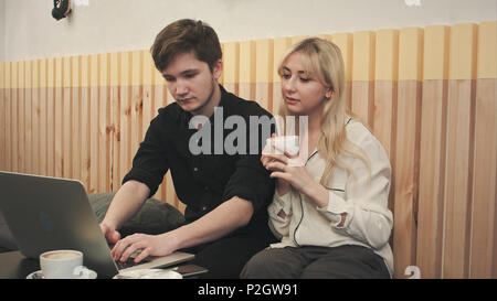 Paar Arbeiten am Laptop, trinken Kaffee im Cafe Stockfoto