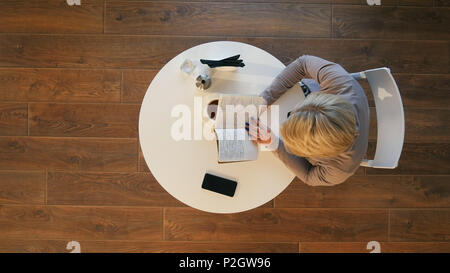 Sonntag Morgen lifestyle Szene der jungen Frau, die ihr Notebook hipster Lesung im Cafe Stockfoto