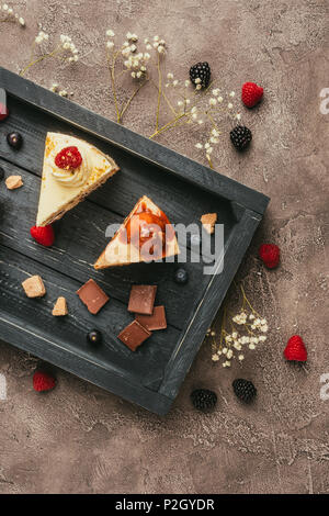 Blick von oben auf die süß lecker Kuchen mit Schokolade und Beeren auf Holz- fach Stockfoto