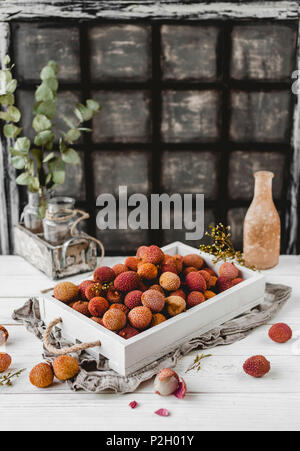 Holzkiste mit litschis auf weißen Tisch Stockfoto