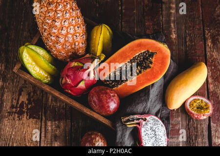 Blick von oben auf die carambolas, Papayas, Ananas, Rambutan, Passionsfrüchte und Mango auf hölzernen Tischplatte Stockfoto