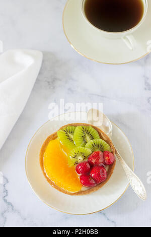 Mini Kuchen oder Torte mit Vanillesauce und verschiedene Früchte in Gelee. Selektive konzentrieren. Stockfoto