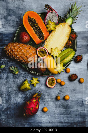 Ansicht von Ananas, Rambutan, pitayas, Passionsfrüchte, Kumquats, Papayas, Karambolen und Mango in der Platte auf dem Tisch Stockfoto