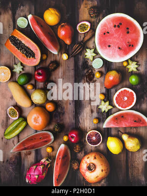 Ansicht der hölzernen Squeezer und Haufen von verschiedenen Früchten auf hölzernen Tisch Stockfoto