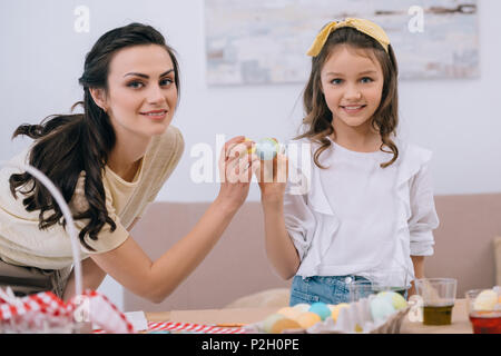 Junge Mutter und Tochter tun Ei tippen auf Ostern Stockfoto