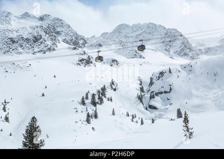 Die Gondeln der Seilbahn am Stubaier Gletscher Skigebiet mit schneebedeckten Bergen im Hintergrund, Neustift im Stubaital, Österreich, Tirol, Österreich Stockfoto