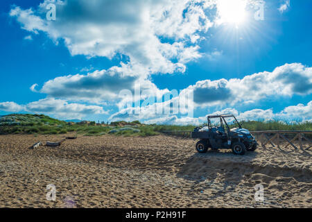 Schwarz quad auf dem sardischen Strand von Porto Ferro an einem bewölkten Morgen Sommer Stockfoto