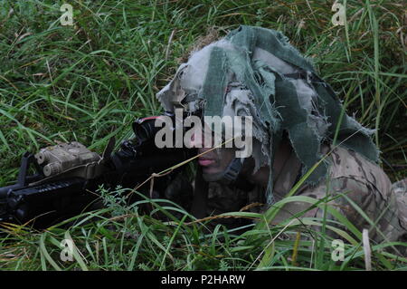 REZEKNE, Lettland - ein Fallschirmjäger ab dem gewählten Unternehmen, 2.BATAILLON, 503Rd Infanterie Regiment (Airborne), 173Rd Infantry Brigade Combat (Airborne), schaut durch seine Tragweite wie Er legt die Unterstützungsfeuer Sept. 24 während der Übung Zobens. Die Übung wurde entwickelt, um die lettische Armee Fähigkeit mit verschiedenen internen und externen Stellen zusammenarbeiten, um ihre Fähigkeiten zu Marschall und ihre Position verteidigen zu testen. Die Fallschirmjäger, zusammen mit Elementen aus dem Lettischen mechanisierte Kräfte, spielte die oppositionelle Kraft für die Übung. Die Fallschirmjäger kam in Lettland zwei Wochen auf ein zu beginnen Stockfoto