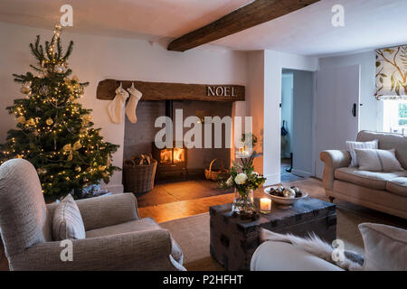 Gemütliche festliche Wohnzimmer mit Kaminecke und Weihnachtsbaum, das Sofa ist von Laura Ashley und die Blinden in der Lewis & Woods Adam's Eden fabric Stockfoto