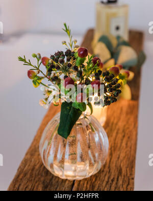 Kleine posey der Beeren auf eine hölzerne Badewanne Regal. Stockfoto