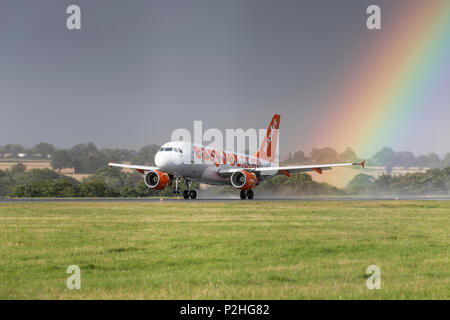 EasyJet Airbus A319 G-EZBC Landung bei starkem Regen Sturm vor einem Regenbogen am 18. August 2017 vom Flughafen London Luton, Bedfordshire, Großbritannien Stockfoto