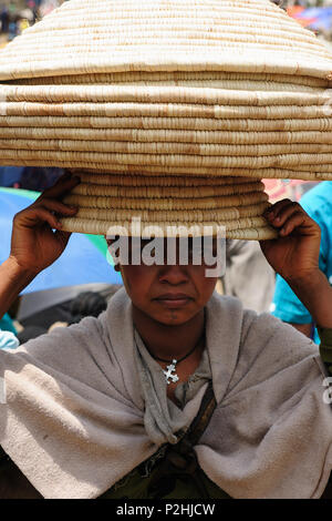 LALIBELA, Äthiopien - 31. AUGUST 2013: Lokale äthiopische Volk, ein Markt Händler im Lalibela Stadt in Äthiopien. Die Frau mit dem großen Korb Baske Stockfoto