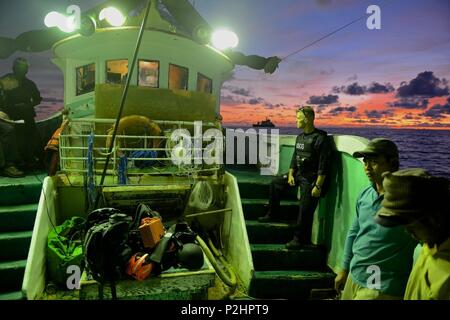 U.S. Coast Guard Petty Officer 1st Class Brett Malone, ein Schaden controlman und Boarding Team Mitglied, kommuniziert mit dem Rest seiner Mannschaft, während die Verwaltung des Fischereifahrzeugs crew an Deck als Boje Ausschreibung USCGC Sequoia (WLB-215) hält Station aus dem Heck der Dschinn Hsing Tsai Nr. 3 im philippinischen Meer, Sept. 2, 2016. Die Mannschaft vier Meere boardings im Laufe von ein paar Tagen die Einhaltung der westlichen und zentralen Pazifik Fischerei Übereinkommen Vorschriften zu gewährleisten. (U.S. Coast Guard Foto von Chief Petty Officer Sara Mooers) Stockfoto