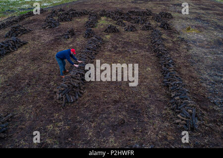 Mann rammen trockenen Rasen in Zeilen im Moor, Renard County Kerry Irland Stockfoto