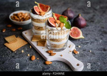 2-in-1-mascarpone Dessert mit zerquetschten Vanille Kekse, Feigen und Mandeln in einem Glas Stockfoto