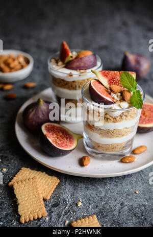 2-in-1-mascarpone Dessert mit zerquetschten Vanille Kekse, Feigen und Mandeln in einem Glas Stockfoto