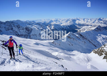 Zwei Personen zurück - Langlauf aufsteigend in Richtung kleiner Kaserer, Stubaier und Zillertaler Alpen im Hintergrund, Hoellschart Stockfoto