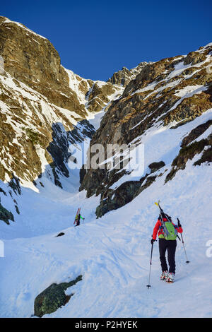 Zwei Personen zurück - Langlauf aufsteigend durch steile Rinne in Richtung Schneespitze, Schneespitze, Tal der Pflersch, Stubai Alp Stockfoto