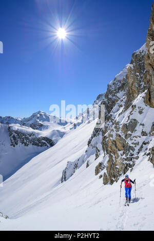 Frau back-country skiing aufsteigend nach La Forcellina, Monte Viraysse im Hintergrund, Col Sautron, Valle Maira, Cottischen Alpen, Stockfoto