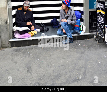 Zwei obdachlose Männer in einem Türrahmen sitzend, The Strand, London, England, UK. Stockfoto