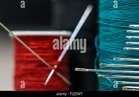 Nähgarne aus verschiedenen Farben mit vielen Nadeln closeup auf Holz- Hintergrund Stockfoto