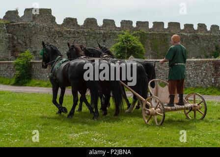 Römisch-antiken Britischen - 4 schwarze Pferd Kampf wagen Demonstration. Lebendige Geschichte Gruppe an Portchester Castle, Hampshire, Großbritannien Stockfoto